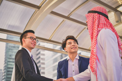 Businessmen shaking hands while client on elevated road