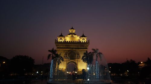 Illuminated building against sky at night