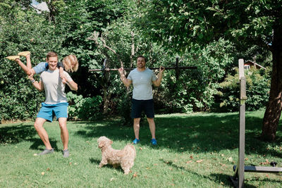 Two men working out together at home with their children and dog