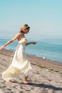 Rear view of woman standing at beach