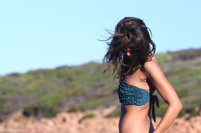 Midsection of woman standing against clear sky