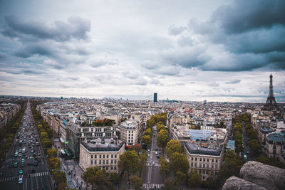 High angle view of city buildings against cloudy sky