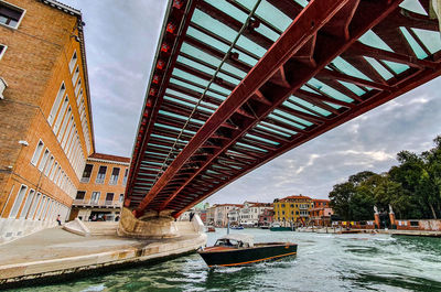 Bridge over canal in city against sky