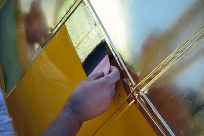 Close-up of man working against wall