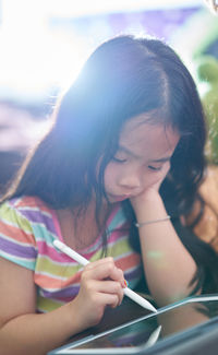 Portrait of a girl looking down tablet