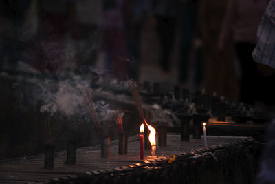 Lit candles in temple against building