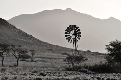 Windmill on field against sky