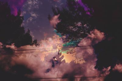 Silhouette of trees against cloudy sky
