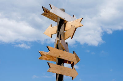 Low angle view of cross on wood against sky