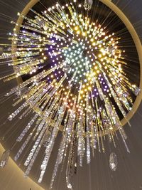 Low angle view of illuminated fireworks against sky at night