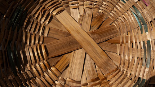 A closeup shot of the bottom of a woven bamboo basket under the sunlight