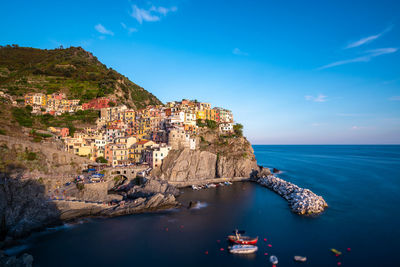 Aerial view of town by sea against sky