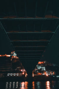 Low angle view of bridge over river at night