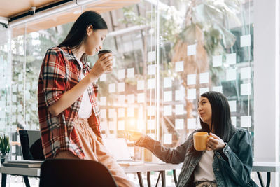 Young woman sitting on table at cafe