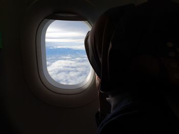 Woman looking through airplane window