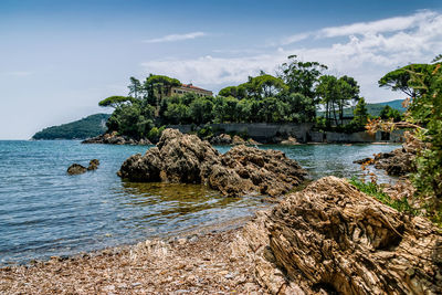 Scenic view of rocks in sea against sky