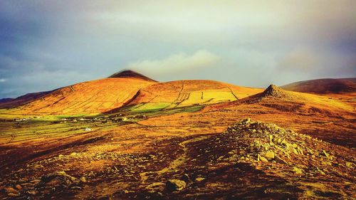 Scenic view of mountains against cloudy sky