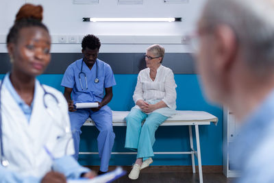 Doctors and nurse talking with patients in clinic