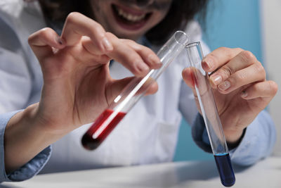 Midsection of scientist examining chemicals in laboratory