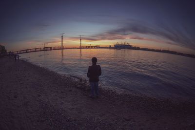 Silhouette of woman in sea at sunset