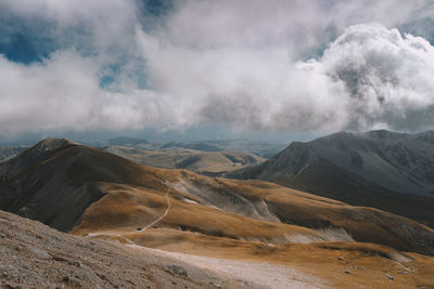 Scenic view of mountains against cloudy sky