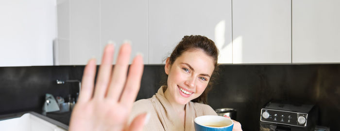 Portrait of young woman using mobile phone at home