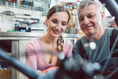 Smiling man and woman working in workshop