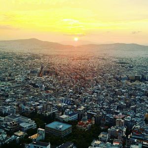 Aerial view of cityscape against sky during sunset