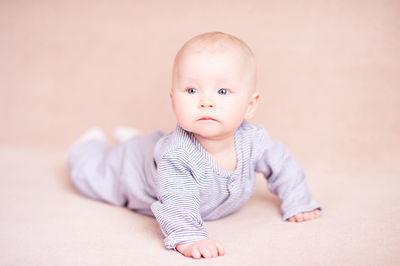 Cute baby boy against beige background
