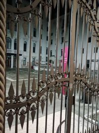 Buildings seen through metal fence