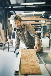 Carpenter working at table in workshop