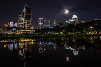 Illuminated buildings against sky at night