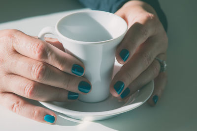 Close-up of hand holding coffee cup