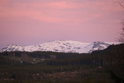 Scenic view of snowcapped mountains against sky at sunset