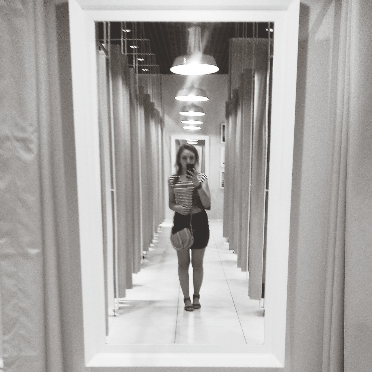 indoors, lifestyles, corridor, full length, standing, architecture, casual clothing, young adult, person, leisure activity, front view, built structure, young women, reflection, door, looking at camera, wall - building feature, ceiling