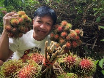 Portrait of smiling woman holding flowering plants