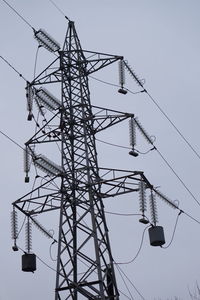 Low angle view of electricity pylon against sky