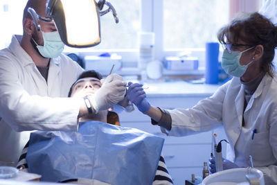 Dentists operating patient in hospital