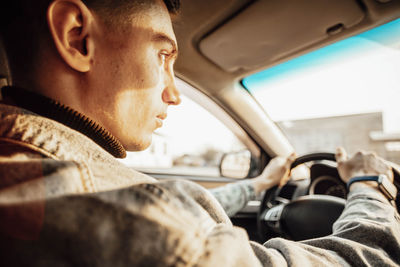 Man holding steering wheel sitting in car. travel background. topic of travel and exploration