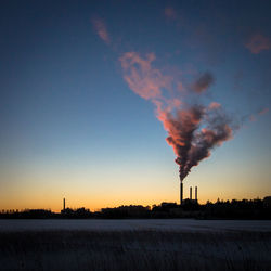 Smoke emitting from chimney against sky