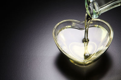 Cooking oil pouring in heart shape bowl on table