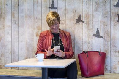 Young woman using smart phone on table