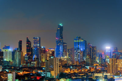 Illuminated cityscape against sky at night