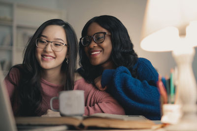 Two women laugh looking at the laptop