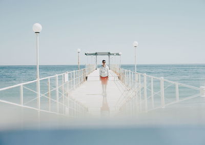 Rear view of man on sea against clear sky