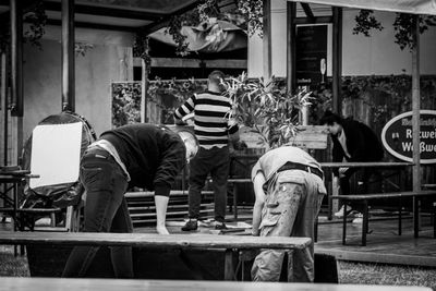 Rear view of people working on chair