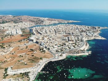 High angle view of sea and cityscape against sky