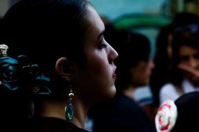 Side view of young woman wearing earring and hair accessory outdoors