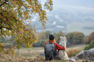 Rear view of man with horse in background