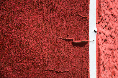 Close-up of cracked red wall